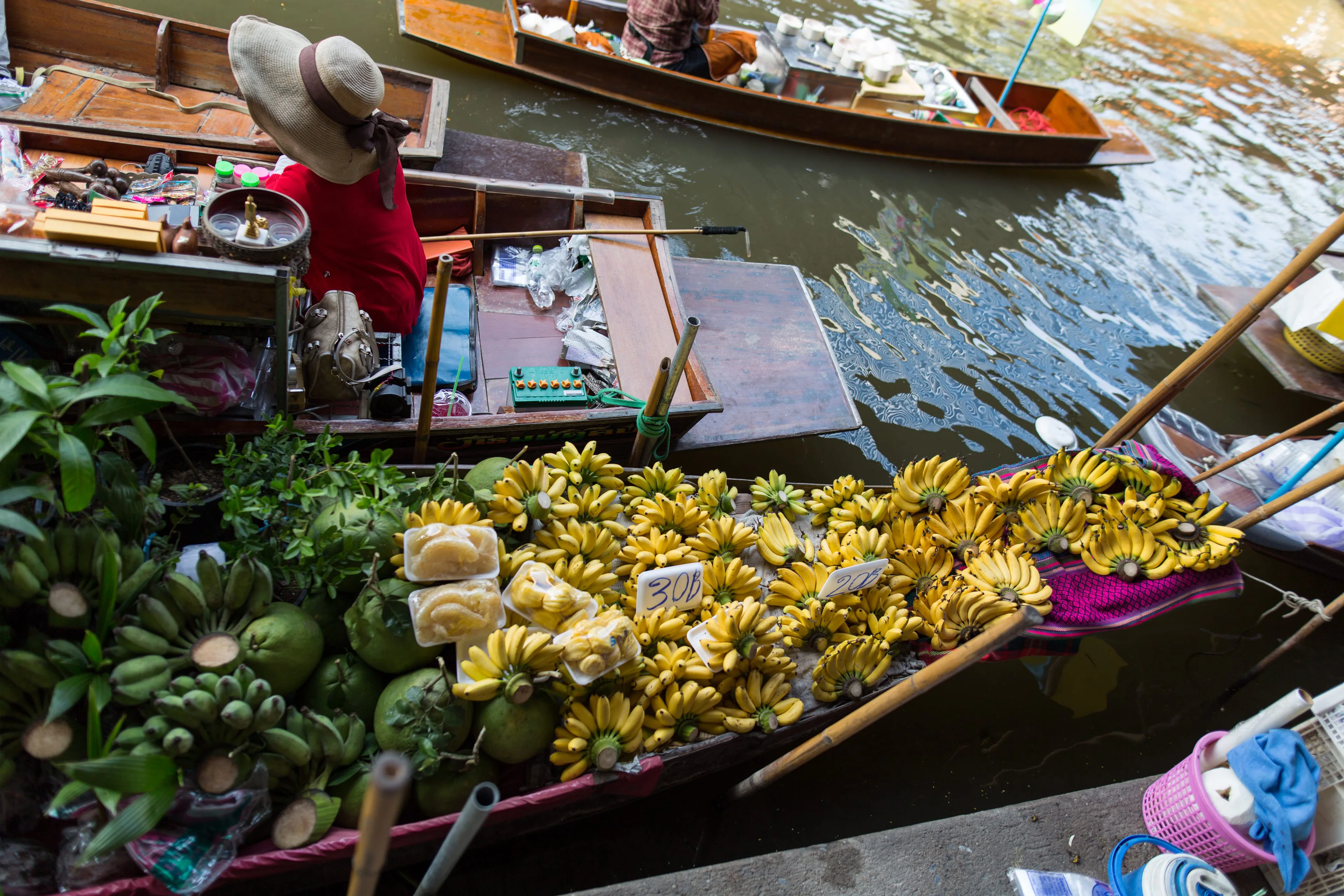 Damnoen Saduak floating market in Thailand: a boat heaped with fruit and greens on the canal